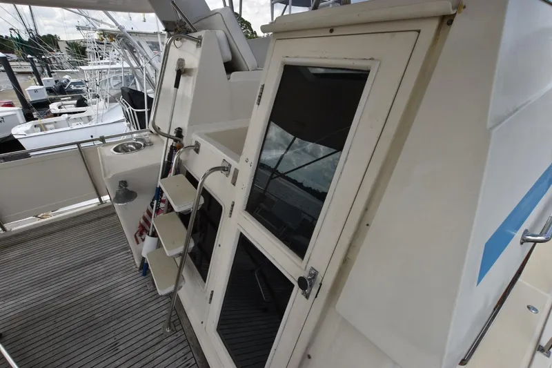 Slide: The Image of 1987 Hartman-Palmer Offshore 38 Sundeck with outdoor sink and steps, docked at marina. - 7