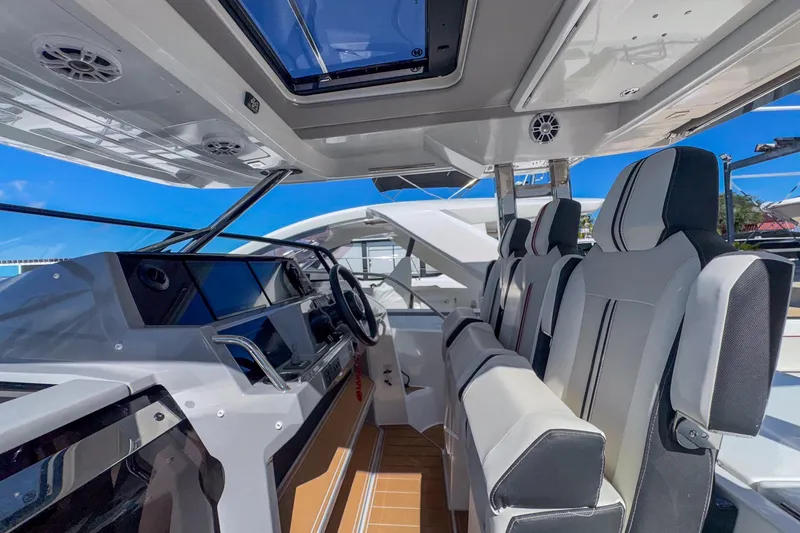 Slide: The Image of Interior of 2022 Jeanneau Leader 12.5 WA boat with modern seating and dashboard. - 13