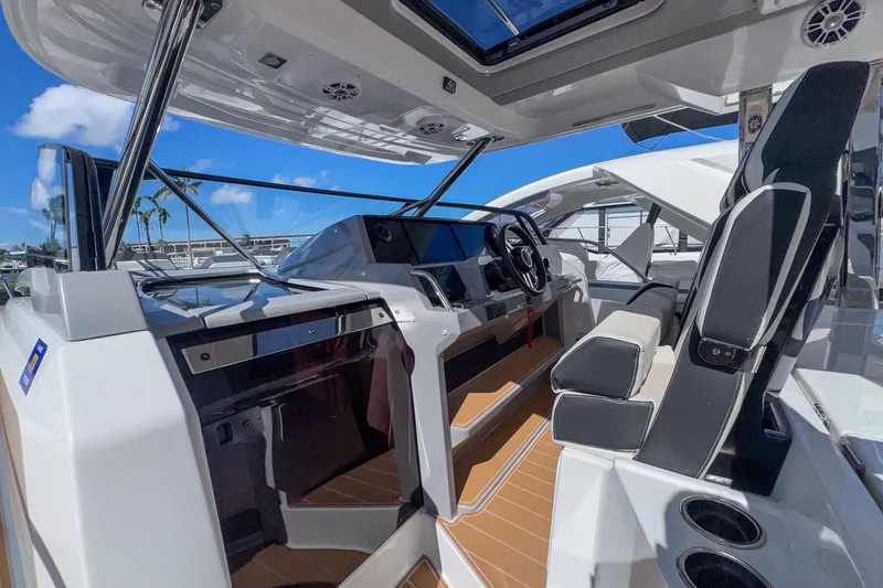 Slide: The Image of 2022 Jeanneau Leader 12.5 WA cockpit with modern helm, seating, and open sky view. - 14
