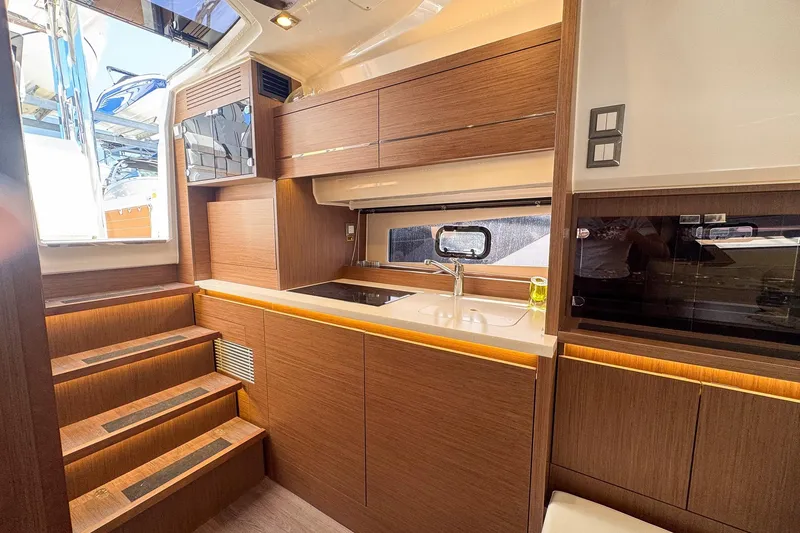 Slide: The Image of Interior of 2022 Jeanneau Leader 12.5 WA yacht, featuring modern kitchen and wooden cabinetry. - 21