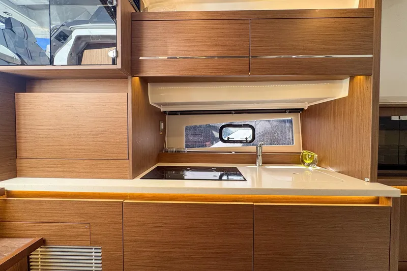 Slide: The Image of Modern kitchen interior on 2022 Jeanneau Leader 12.5 WA yacht, featuring sleek wood cabinetry. - 27