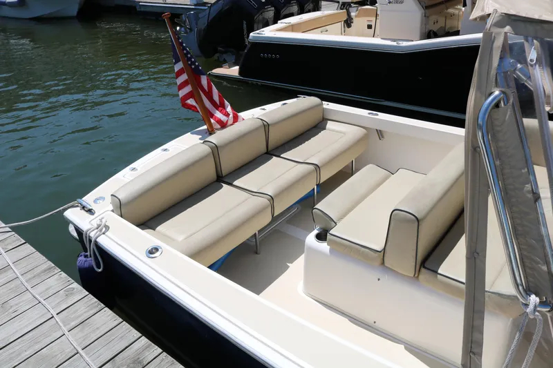 Slide: The Image of 2013 Hunt Harrier boat docked at marina with modern buildings in background. - 10