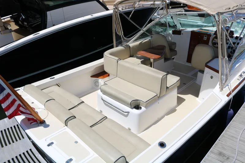 Slide: The Image of 2013 Hunt Harrier boat docked, featuring a beige canopy and sleek design. - 11