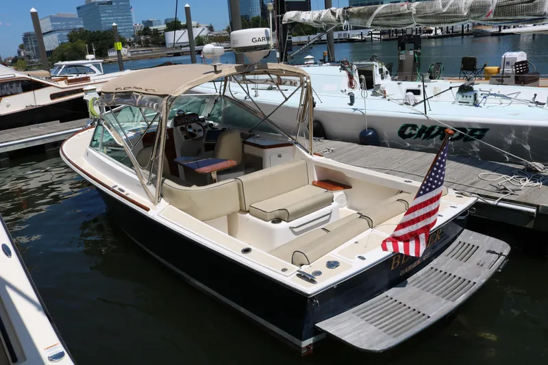 Slide: The Image of 2013 Hunt Harrier boat with beige seating and American flag at dock. - 13