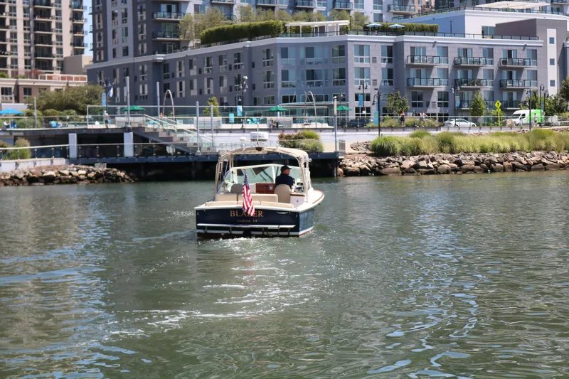 Slide: The Image of Boat on water near modern buildings, Hunt Harrier 2013 model, with American flag. - 22