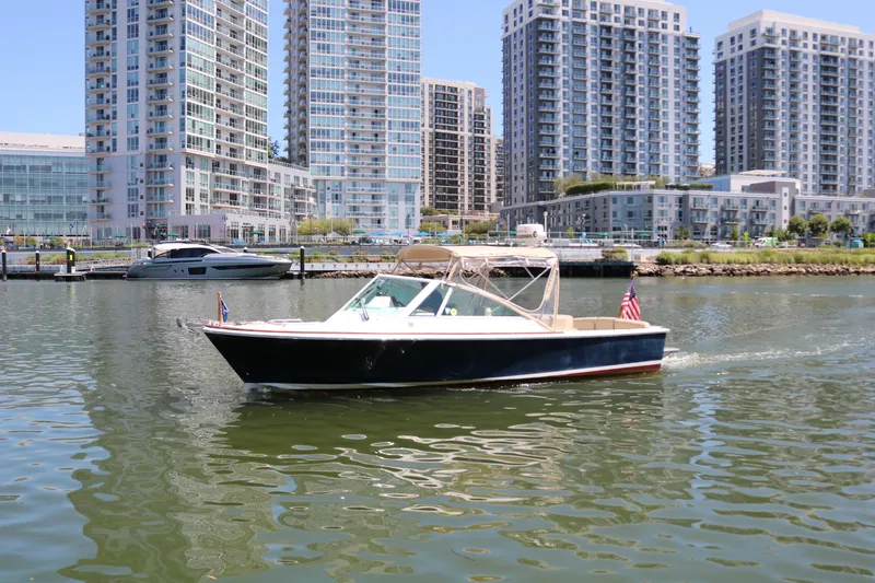 Slide: The Image of 2013 Hunt Harrier boat cruising in urban waterfront with tall buildings in background. - 27