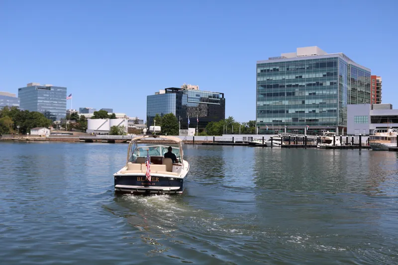 Slide: The Image of Boat cruising in urban harbor, modern buildings in background, clear blue sky. Hunt Harrier 2013. - 30