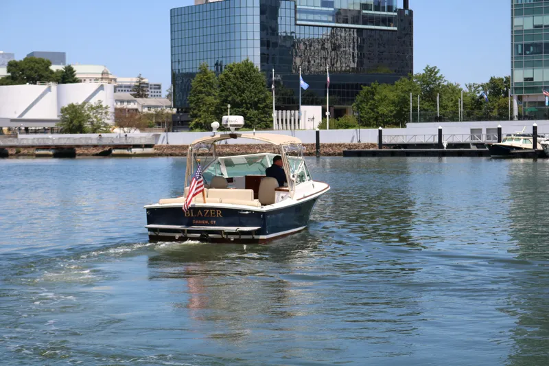 Slide: The Image of 2013 Hunt Harrier boat cruising in urban waterfront with American flag. - 31