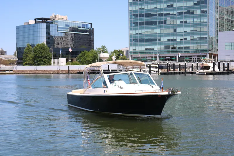 Slide: The Image of 2013 Hunt Harrier boat cruising near modern waterfront buildings. - 32