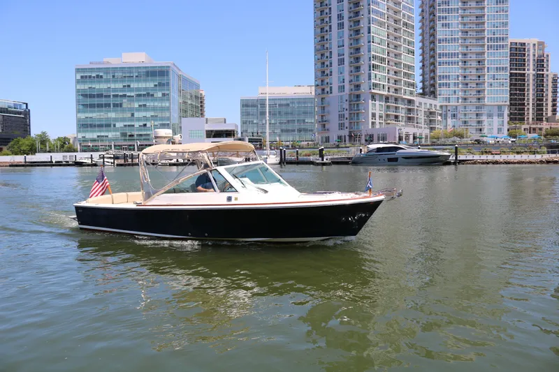 Slide: The Image of 2013 Hunt Harrier boat cruising in urban waterfront with modern buildings. - 33