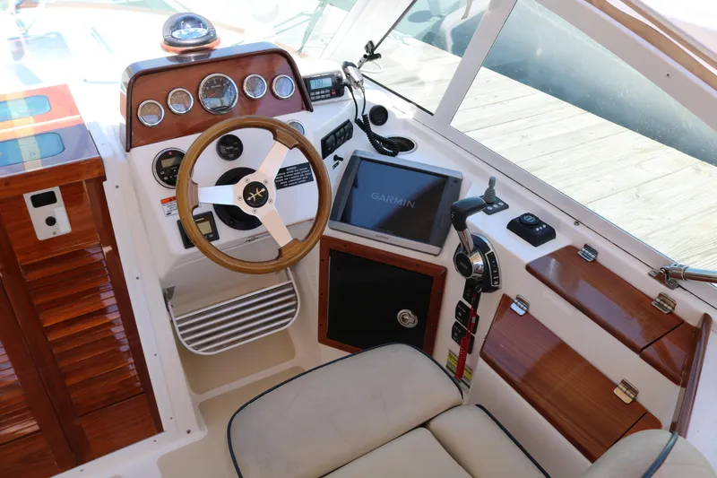 Slide: The Image of 2013 Hunt Harrier boat docked, featuring beige seating and a clear canopy. - 6