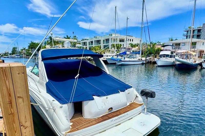 Slide: The Image of 1997 Sea Ray 400 Sundancer docked in a marina, surrounded by other boats. - 1
