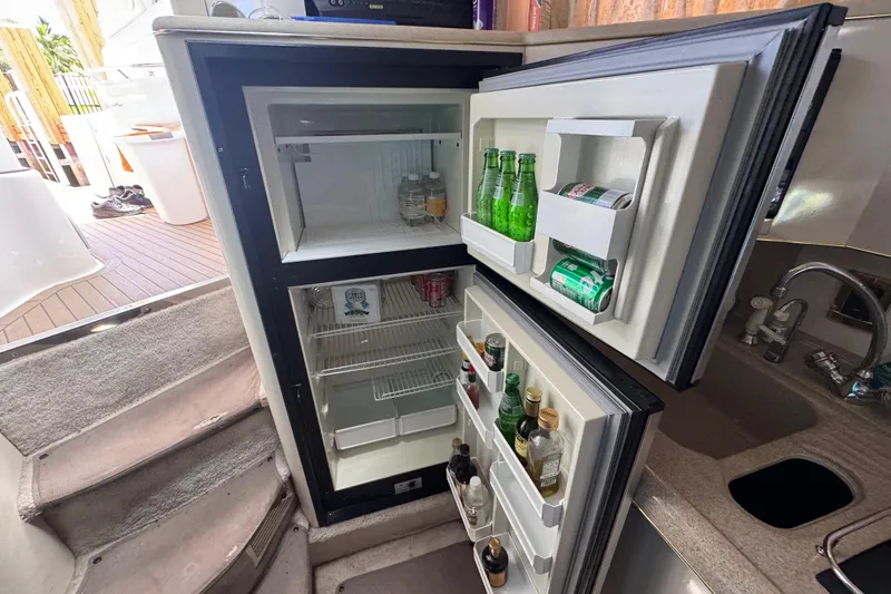 Slide: The Image of Open fridge on 1997 Sea Ray 400 Sundancer yacht, stocked with beverages. - 13
