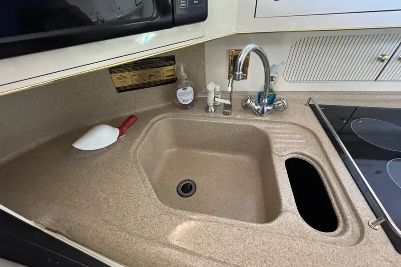 Slide: The Image of 1997 Sea Ray 400 Sundancer kitchen sink with faucet and countertop accessories. - 14