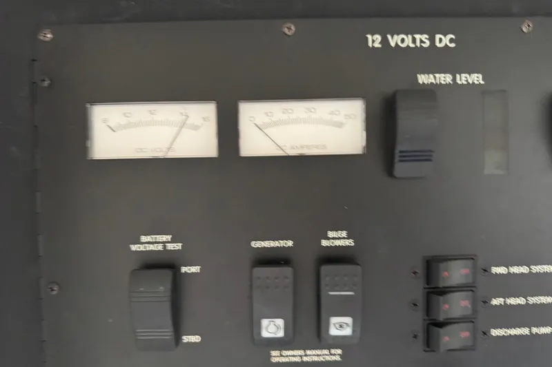 Slide: The Image of Control panel of a 1997 Sea Ray 400 Sundancer boat, showing voltage and amperage gauges. - 26