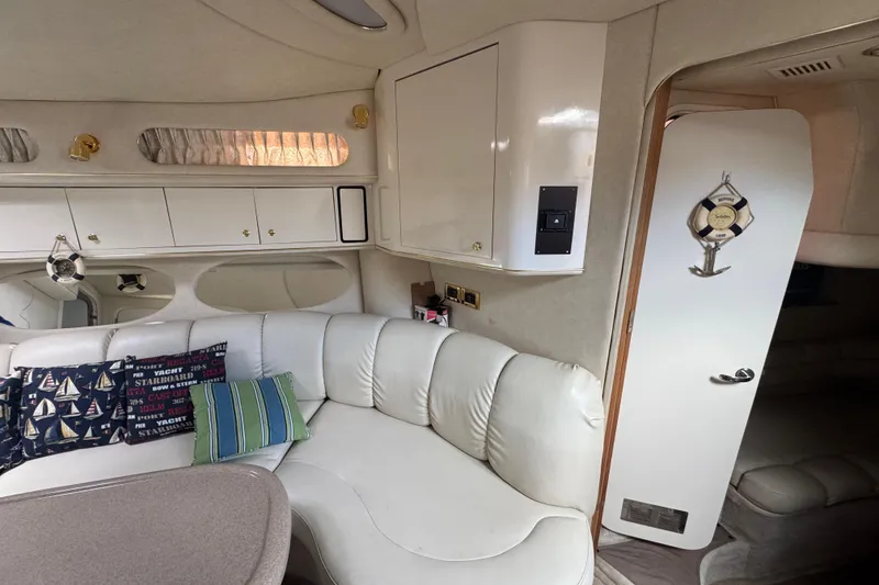 Slide: The Image of Interior of a 1997 Sea Ray 400 Sundancer yacht with white leather seating and nautical decor. - 29