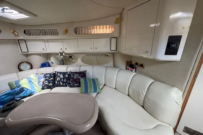 Slide: The Image of Interior of 1997 Sea Ray 400 Sundancer with white leather seating and nautical-themed pillows. - 30