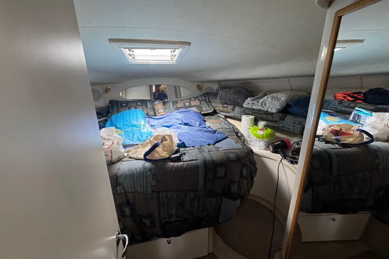 Slide: The Image of Cozy cabin interior of 1997 Sea Ray 400 Sundancer with bed and personal items. - 32