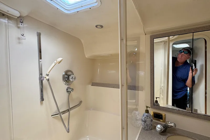 Slide: The Image of 1997 Sea Ray 400 Sundancer bathroom with shower, mirror, and sink area. - 38