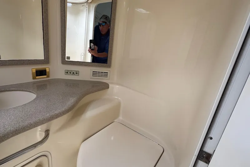 Slide: The Image of 1997 Sea Ray 400 Sundancer bathroom with sink, mirror, and beige interior. - 40