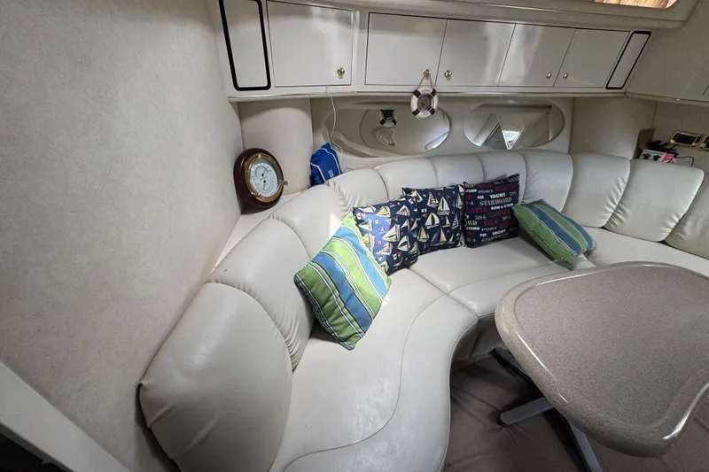 Slide: The Image of Interior of 1997 Sea Ray 400 Sundancer with white leather seating and nautical-themed pillows. - 41