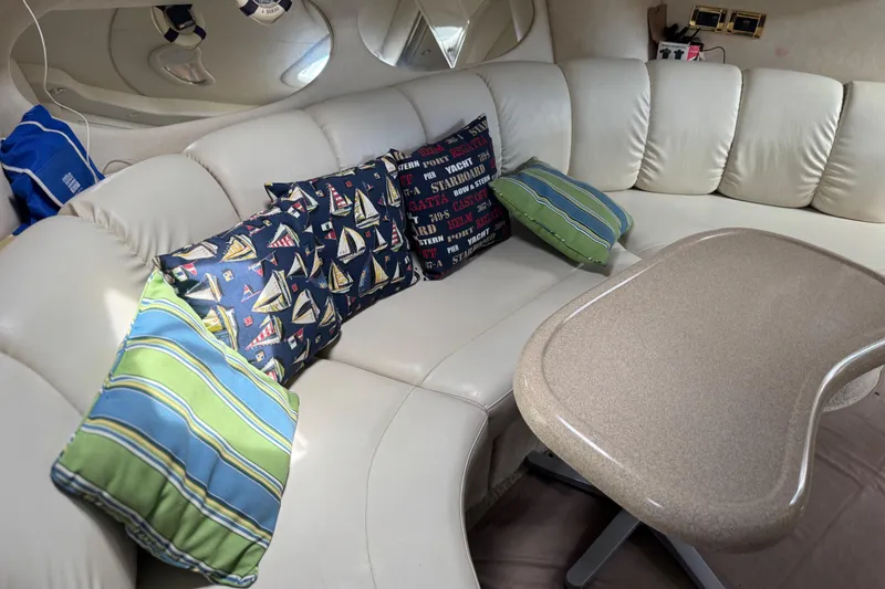 Slide: The Image of Interior of 1997 Sea Ray 400 Sundancer with plush seating and nautical-themed pillows. - 43