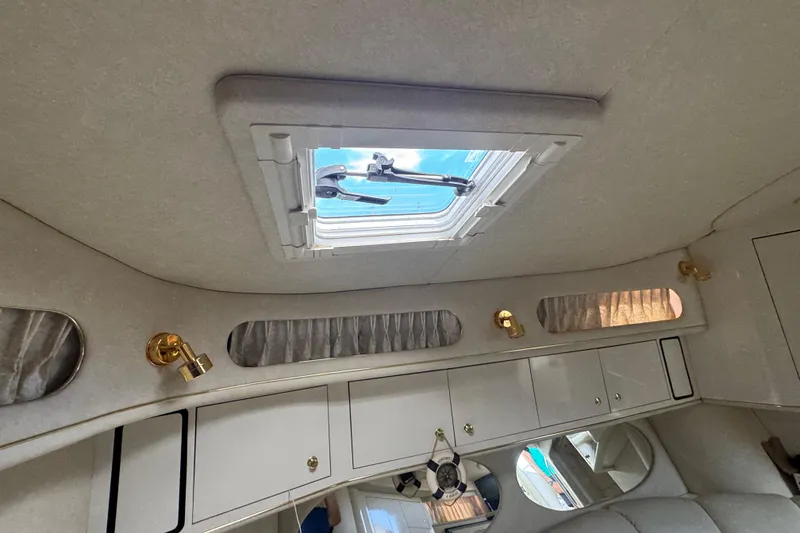 Slide: The Image of Interior cabin of 1997 Sea Ray 400 Sundancer with skylight and gold fixtures. - 47
