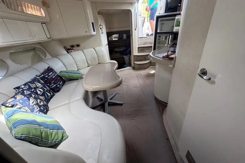 Slide: The Image of Interior of 1997 Sea Ray 400 Sundancer yacht with white seating and nautical-themed pillows. - 49