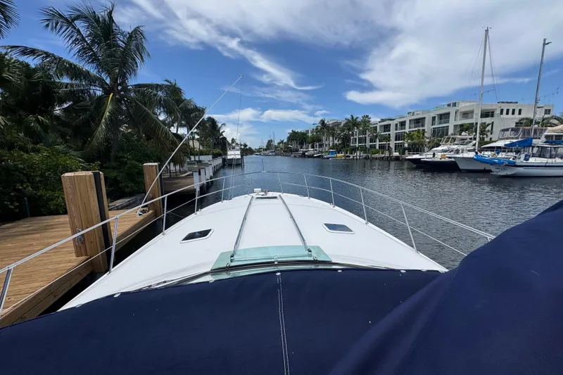 Slide: The Image of 1997 Sea Ray 400 Sundancer yacht docked in a scenic marina with palm trees. - 62