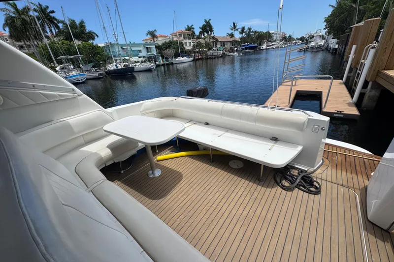 Slide: The Image of 1997 Sea Ray 400 Sundancer yacht deck with seating and table, docked by a canal. - 65