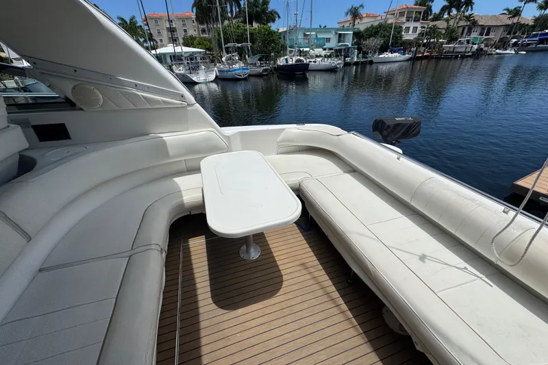 Slide: The Image of 1997 Sea Ray 400 Sundancer yacht with spacious seating and table, docked by the marina. - 67