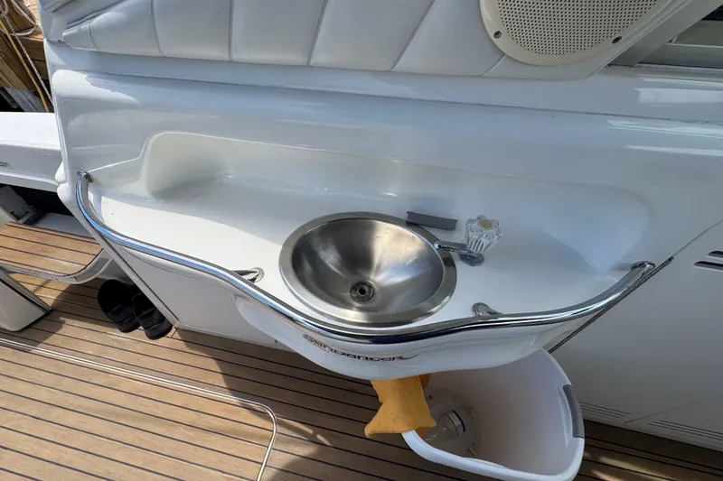 Slide: The Image of 1997 Sea Ray 400 Sundancer yacht sink with stainless steel basin and wooden deck. - 76