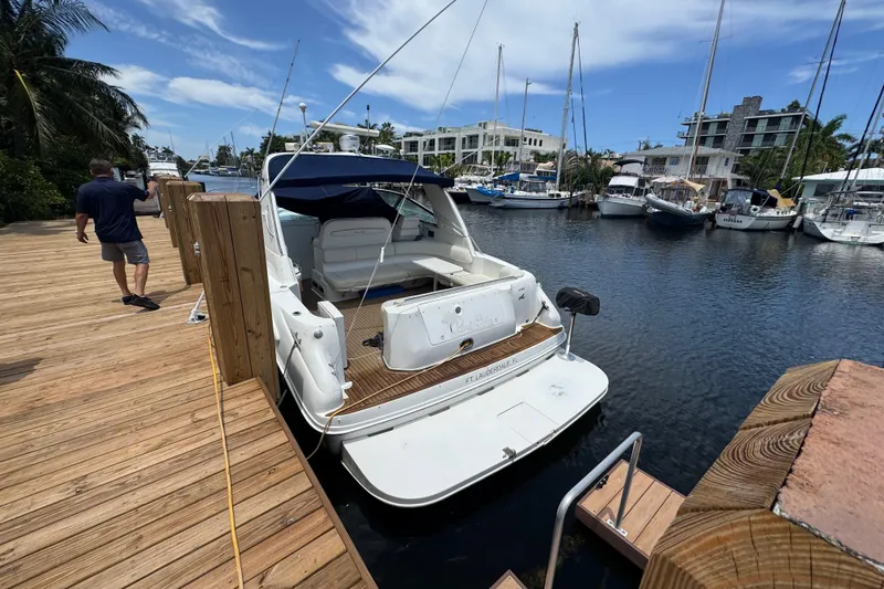 Slide: The Image of 1997 Sea Ray 400 Sundancer docked at marina, sunny day, wooden pier, boats in background. - 79