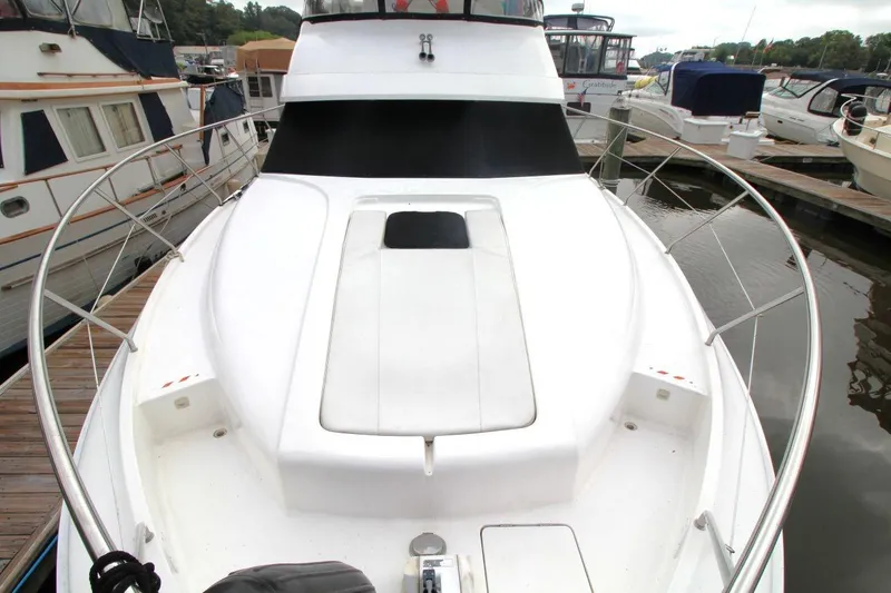 Slide: The Image of 1997 Silverton 402 Motor Yacht docked at marina, showcasing spacious deck and sleek design. - 11