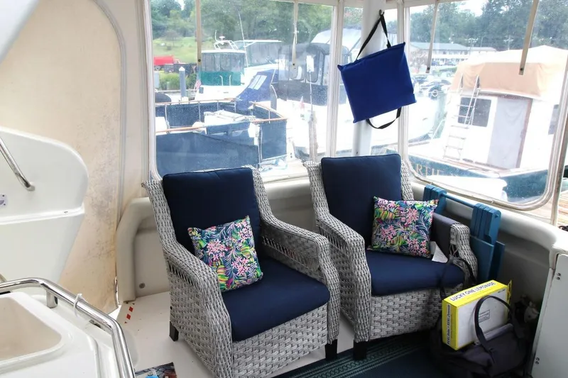 Slide: The Image of Interior of 1997 Silverton 402 Motor Yacht with wicker chairs and colorful cushions. - 13