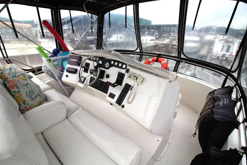 Slide: The Image of 1997 Silverton 402 Motor Yacht helm with steering wheel, controls, and marina view. - 15