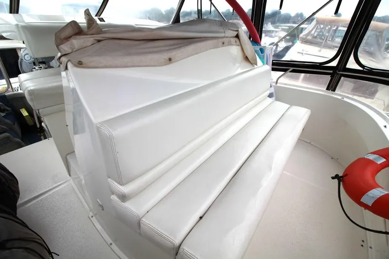Slide: The Image of 1997 Silverton 402 Motor Yacht interior with white seating and life preserver. - 16