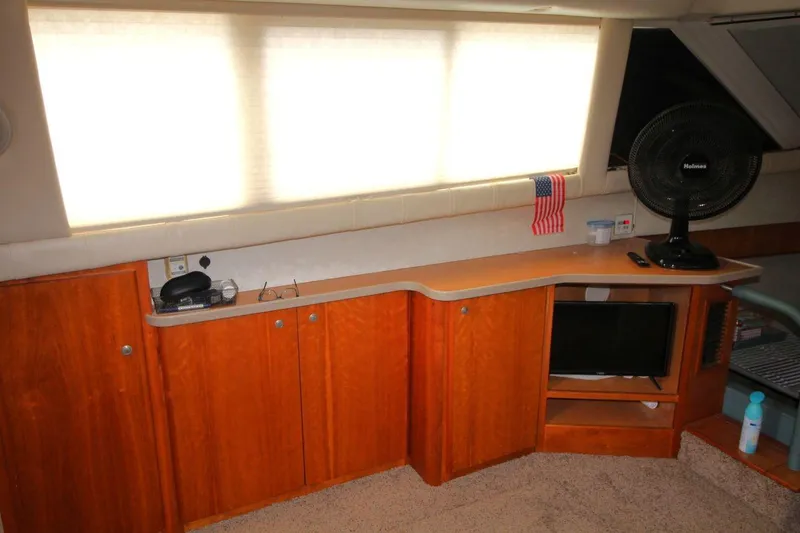 Slide: The Image of Interior of 1997 Silverton 402 Motor Yacht with wooden cabinets and a small TV. - 22