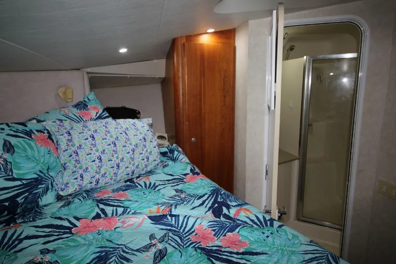 Slide: The Image of 1997 Silverton 402 Motor Yacht bedroom with floral bedding and ensuite bathroom. - 27