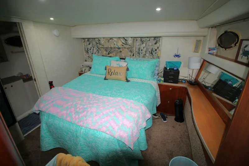 Slide: The Image of Cozy bedroom in 1997 Silverton 402 Motor Yacht with teal bedding and decorative pillows. - 29