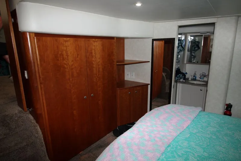 Slide: The Image of Interior of 1997 Silverton 402 Motor Yacht with wood cabinetry and cozy bedding. - 30