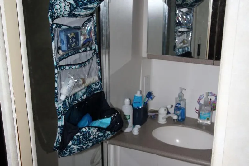 Slide: The Image of Bathroom of 1997 Silverton 402 Motor Yacht with toiletries and hanging organizer. - 32
