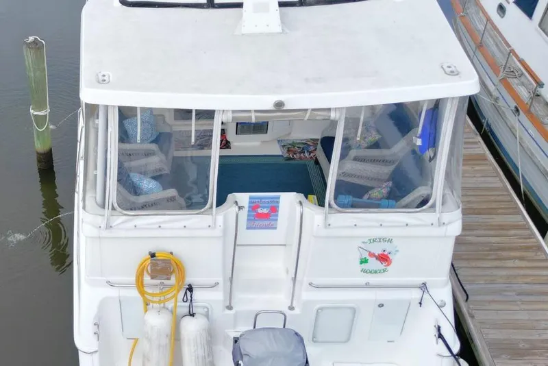 Slide: The Image of 1997 Silverton 402 Motor Yacht docked, rear view with enclosed seating area. - 6