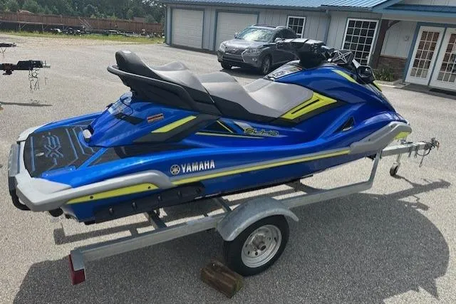 Slide: The Image of 2020 Yamaha WaveRunner FX Cruiser SVHO on trailer, blue and yellow design, parked outdoors. - 6