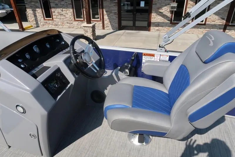 Slide: The Image of 2021 Bennington 21 LL boat interior with steering wheel and blue-gray captain's chair. - 16