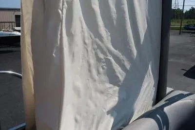 Slide: The Image of 2021 Bennington 21 LL boat with beige fabric cover in outdoor setting. - 20