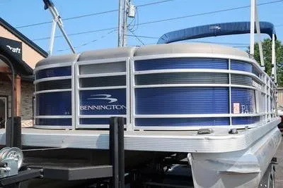 Slide: The Image of 2021 Bennington 21 LL pontoon boat with blue exterior, docked outdoors. - 4