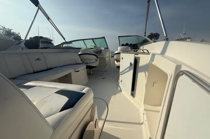 Slide: The Image of 2008 Monterey 254FS boat interior with white seating and steering console. - 11