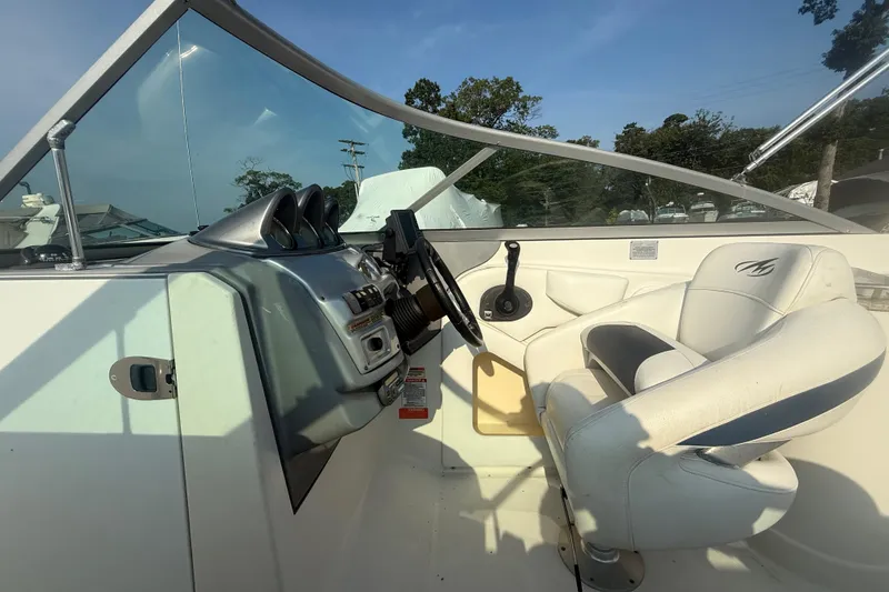 Slide: The Image of 2008 Monterey 254FS boat cockpit with steering wheel and white captain's chair. - 14
