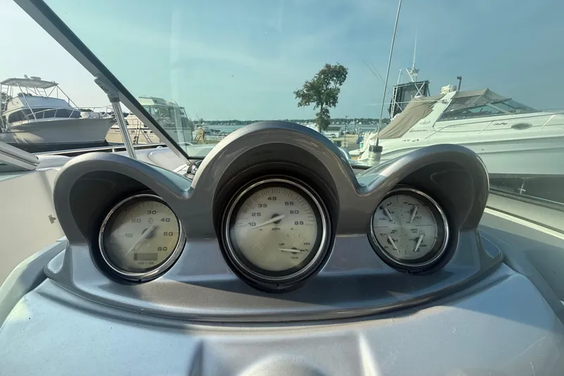 Slide: The Image of Dashboard of a 2008 Monterey 254FS boat with gauges, docked at a marina. - 16